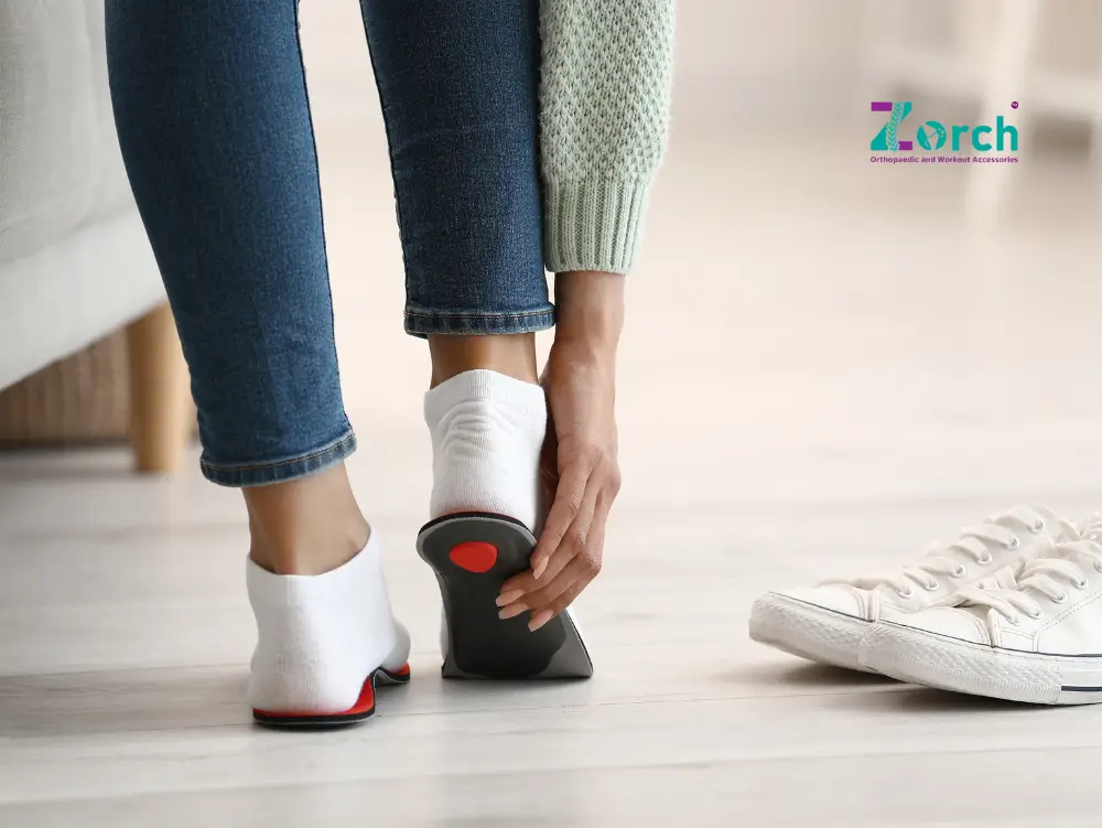 Inserting a shoe insole into a white sneaker, demonstrating how individuals might use insoles to address flat feet. This image relates directly to the query, "Can shoe insoles correct flat feet?